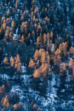 Sun hitting sharp mountains covered in snow Stock Photos