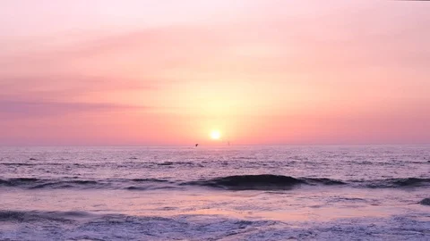 Sun on horizon at sunset over ocean. Slow zoom in with sailing yacht in distance Stock Footage 115920913