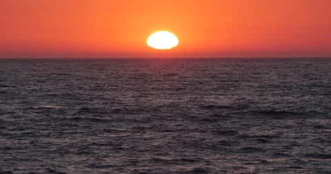 Sun on horizon at sunset over ocean Stock Footage 135046847