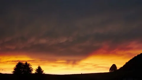 The sun illuminates the clouds in fiery colors after the storm. Video stock 198227716