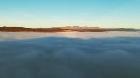 The sun illuminates a misty landscape with mountains and valleys. Stock Footage 296964068