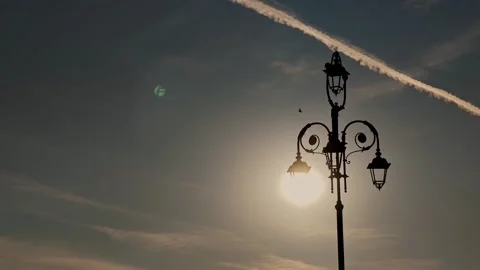 Sun imitating glowing lightbulb inside vintage street light silhouette with Stock Footage 343792553