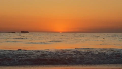 Sun just below the horizon casting an orange glow on the horizon above the ocean Video stock 144575119