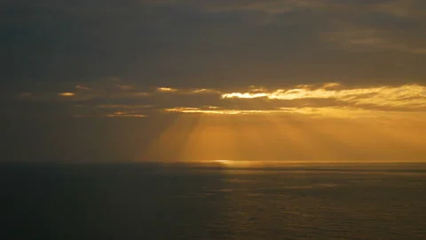 Sun light beam from the sky at sunset time over the sea wave Stock Footage 134825426