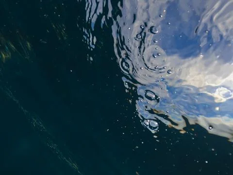 Sun light beams shining from above coming through the ocean deep blue water Stock Photos