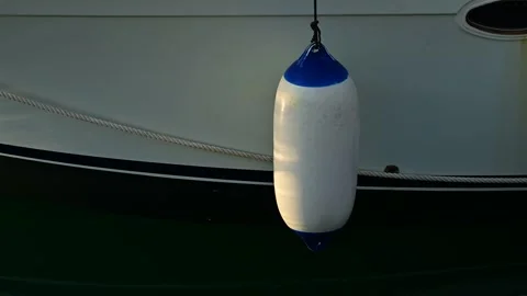 Sun light dancing on white buoys tied to moored yacht Stock Footage 317980551