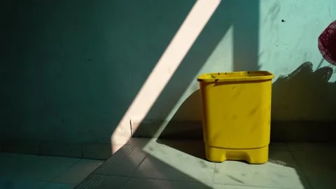 Sun light fall on a yellow trash bin . Stock Footage 266568193
