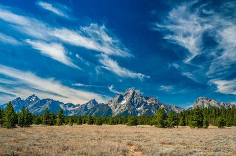 Sun light shines down upon the mountain range of The Grand Tetons. Stock Photos