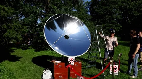 Sun lights reflector at fair show, green park environment, man give cooked piece Video stock 66262932