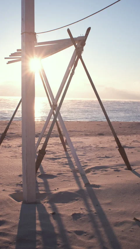 The sun lights through construction from paddles on the beach near the sea edge. Stock Footage 168536623