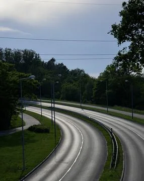 Sun lit asphalt curved empty road. Stock Photos