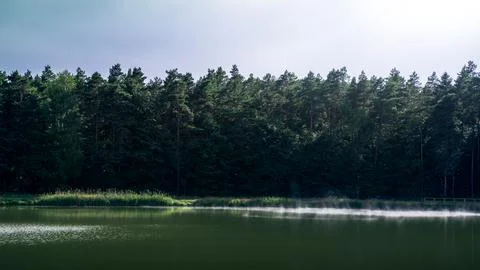 The sun-lit mist floating over the lake. Krasnobrd, Poland Stock Photos