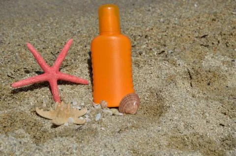 Sun Lotion on Beach Sand Stock Photos