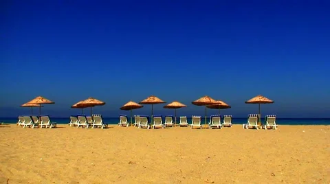 Sun loungers on an empty beach with clear blue sky 1 Video stock 938326