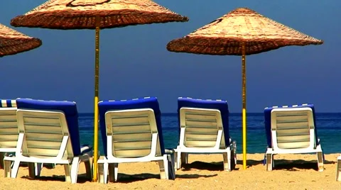 Sun loungers on an empty beach with clear blue sky 3 Stock Footage 938414