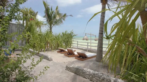 Sun loungers in perfect setting overlooking the sea on tropical island Stock Footage 148530548