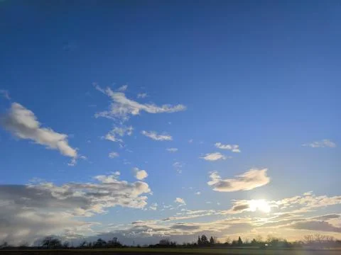 The sun is low over the fields and meadows - the first sunset glow appears .. Stock Photos
