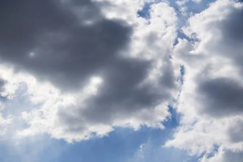 The sun makes the way through dark clouds in the blue sky. Stock-Fotos