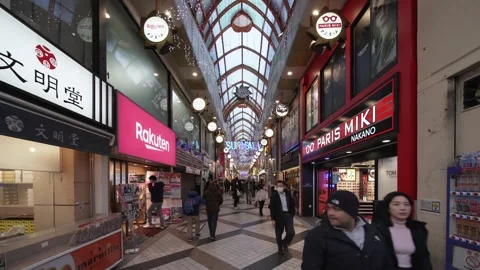 Sun Mall shopping arcade featuring storefronts like Rakuten and Paris Miki. Stock Footage 303441188