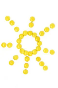 Sun of many small round yellow candies isolated on a white background Stock Photos