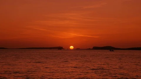 Sun melting into horizon between mountain islands Stock Footage 123090306
