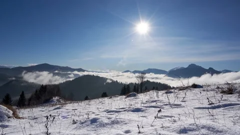 Sun moving across the blue sky , snow landscape with mountains and hills, Video stock 167838618