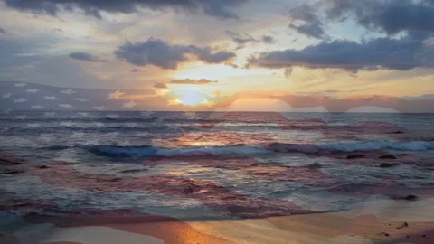 Sun moving horizon starting light shift, waves rolling shore, flag overlay Stock Footage 334694132
