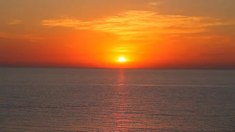 Sun orange sets at sunset over sea with waves Stock Footage 158621816