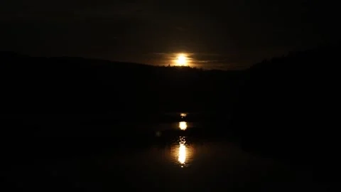 The sun over the lake in the mountains appears gradually out of the darkness Stock Footage 247923020