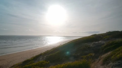 Sun over ocean with grassy sand dunes 4K Stock-Footage 233483802