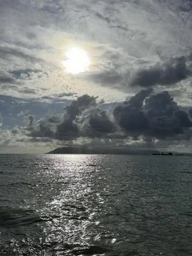 Sun Over the Sea Through Dramatic Clouds 库存照片