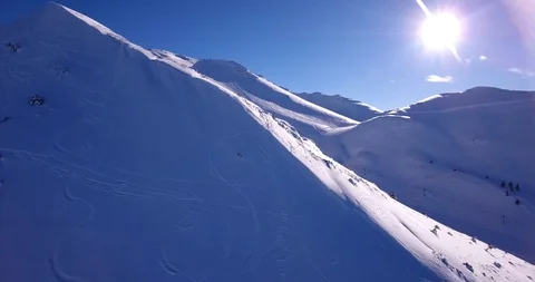 Sun over ski tracks and ridge on steep off piste slope Stock Footage 93456323