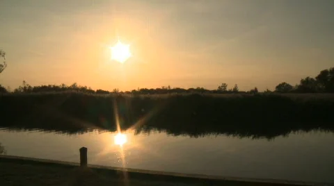 Sun over water and reflected in the water on the Norfolk Broads Stock Footage 860419
