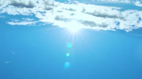 Sun over white clouds in clear blue sky time lapse, motion. Sun Closeup, Sunshin Stock Footage 314648615