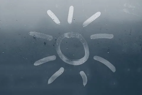 The sun painted on a fogged window Stock Photos