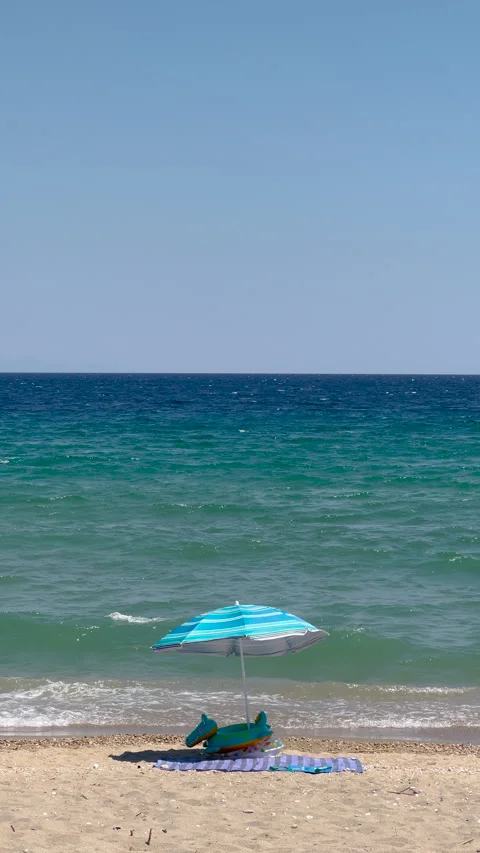Sun parasol on sandy beach on a windy and sunny day 스톡 동영상 280584605