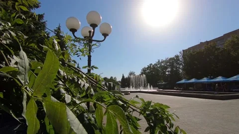 The sun in the park shines through a lantern and a fountain. Stock Footage 141135716