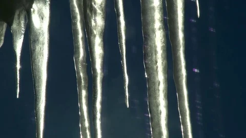 Sun passing behind some icicles on a sunny winter day Stock Footage 93782807