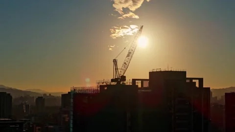 Sun Passing Behind Tower Crane Over City 스톡 동영상 314120815