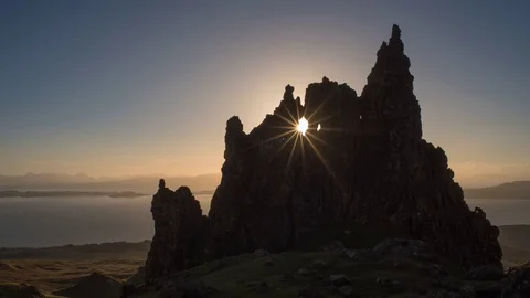 Sun passing through hole in rock at dawn Stock Footage 69958975