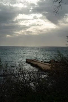 Sun passing thru the clouds over ocean pier, Malta Stock Photos