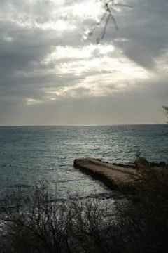 Sun passing thru the clouds over ocean pier, Malta Stock Photos