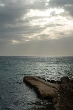 Sun passing thru the clouds over ocean pier, Malta Stock Photos