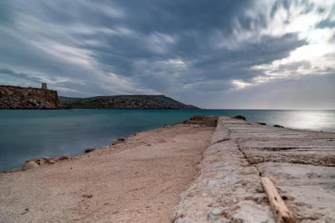 Sun passing thru the clouds over ocean pier, Malta Stock Photos
