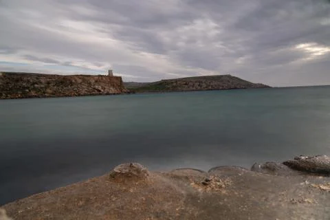 Sun passing thru the clouds over ocean pier, Malta 스톡 사진