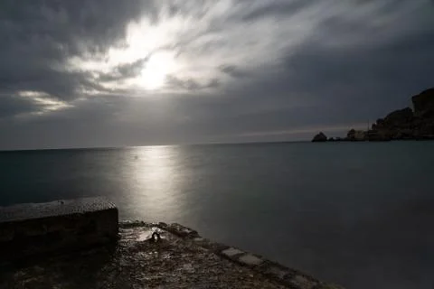 Sun passing thru the clouds over ocean pier, Malta Stock Photos