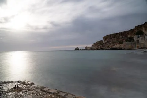 Sun passing thru the clouds over ocean pier, Malta Stock Photos