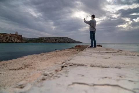 Sun passing thru the clouds over ocean pier, Malta Stock Photos