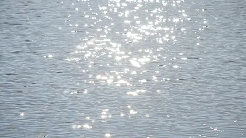 Sun path on light blue water with golden sunny bokeh circles Stock Footage 76274079