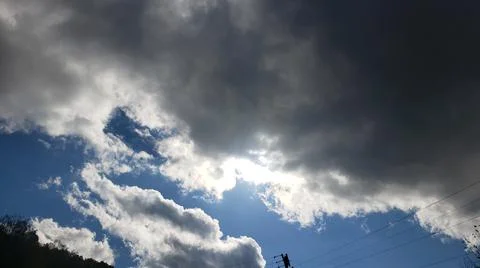 Sun Peaking Through Dark Clouds Фото